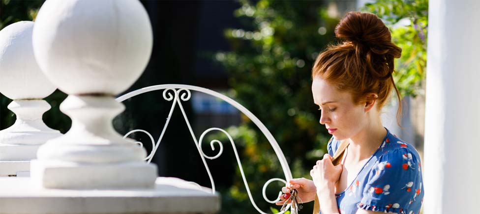 young woman at gate arriving home